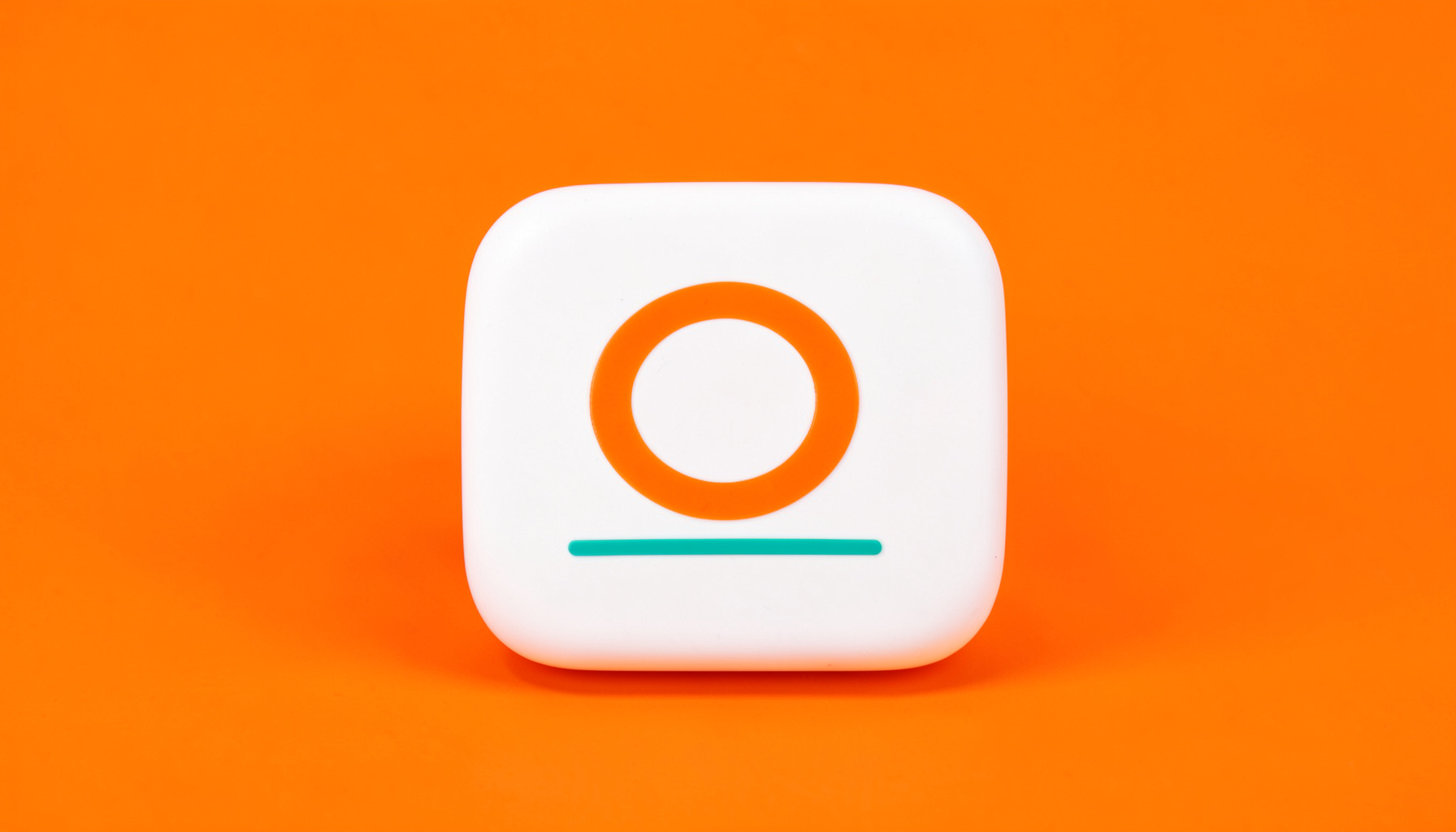A studio photograph on a seamless off-white backdrop of a rounded white tile with a simple orange circular emblem and a teal underline detail.