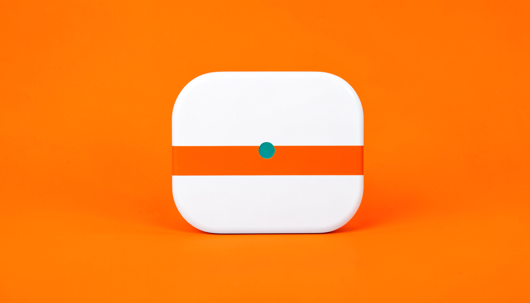 A studio photograph on a seamless white backdrop of a rounded tile with a bold orange accent stripe and a small teal dot, minimal and modern.